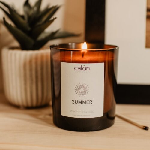 Pink pepper and rose summer candle on shelf Pink pepper and rose summer candle