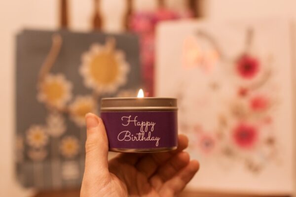 Happy birthday mini tin candle - held in hand